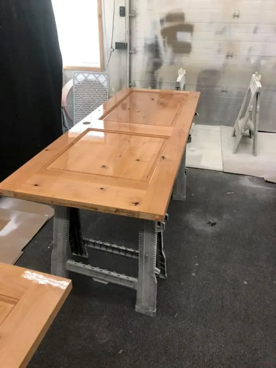 A wooden table is sitting in a room next to a window