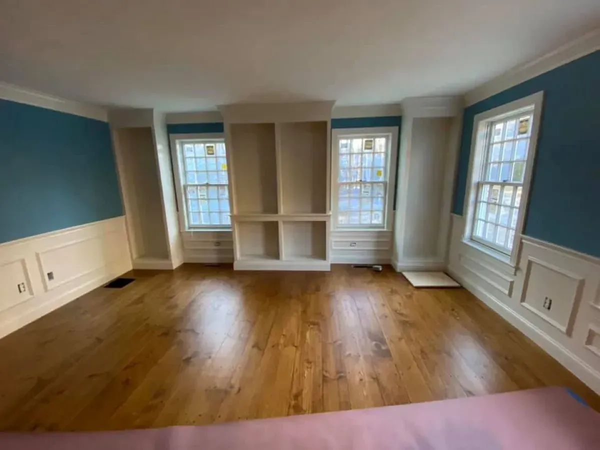 An empty living room with hardwood floors and blue walls.