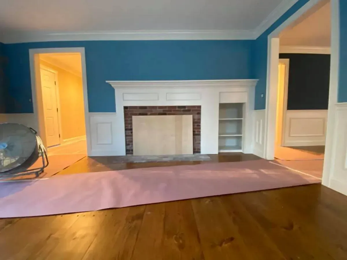 A living room with blue walls and a fireplace