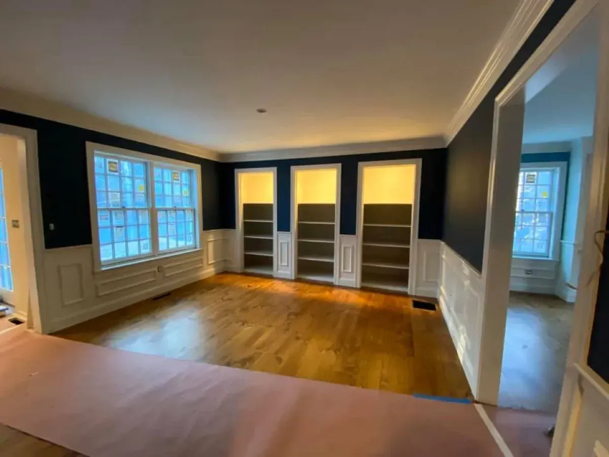 A living room with a lot of windows and shelves