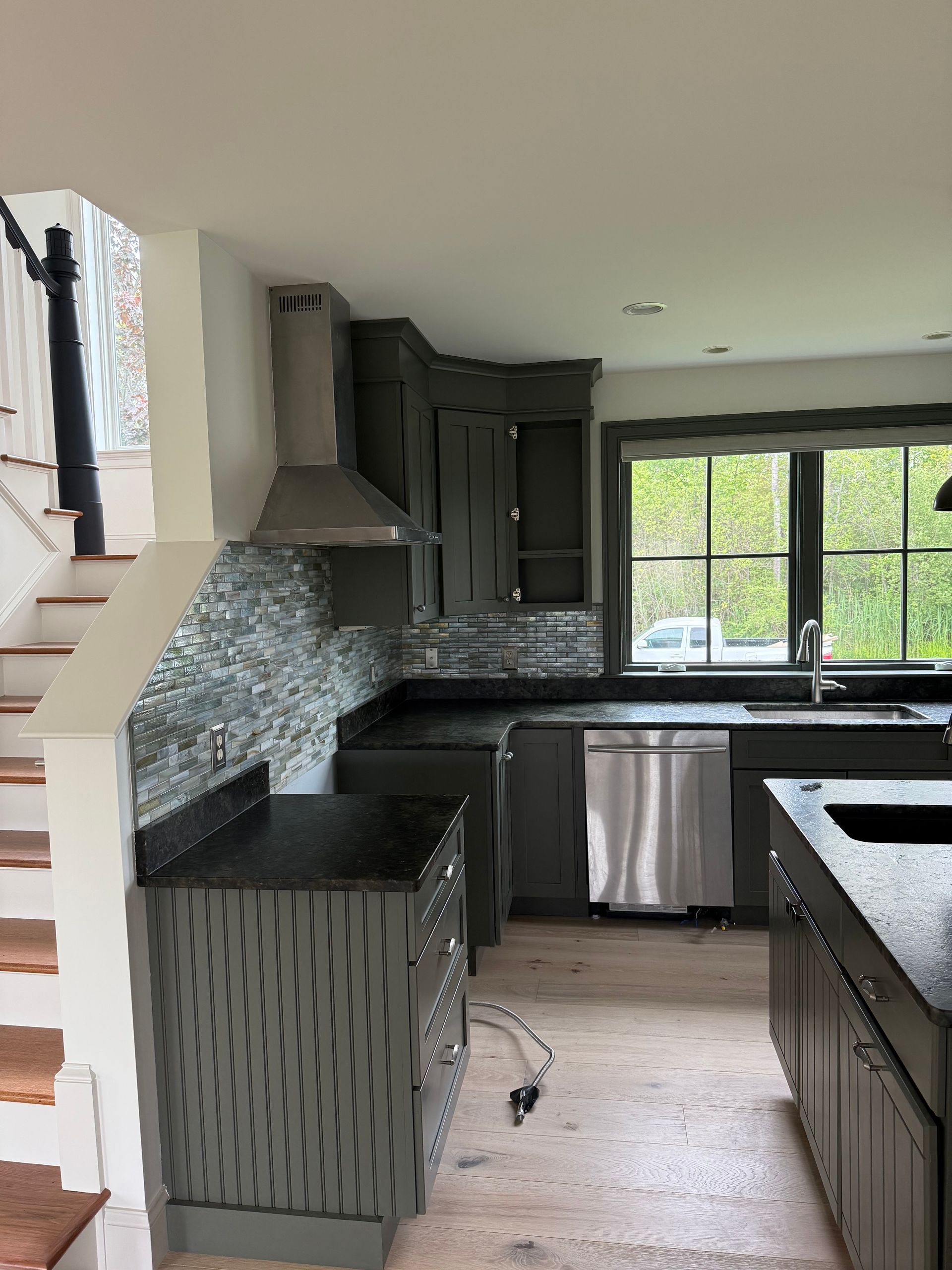 A hallway with a wooden floor and a reflection of a window.
