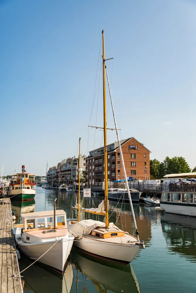 A group of sailboats are docked in a harbor.