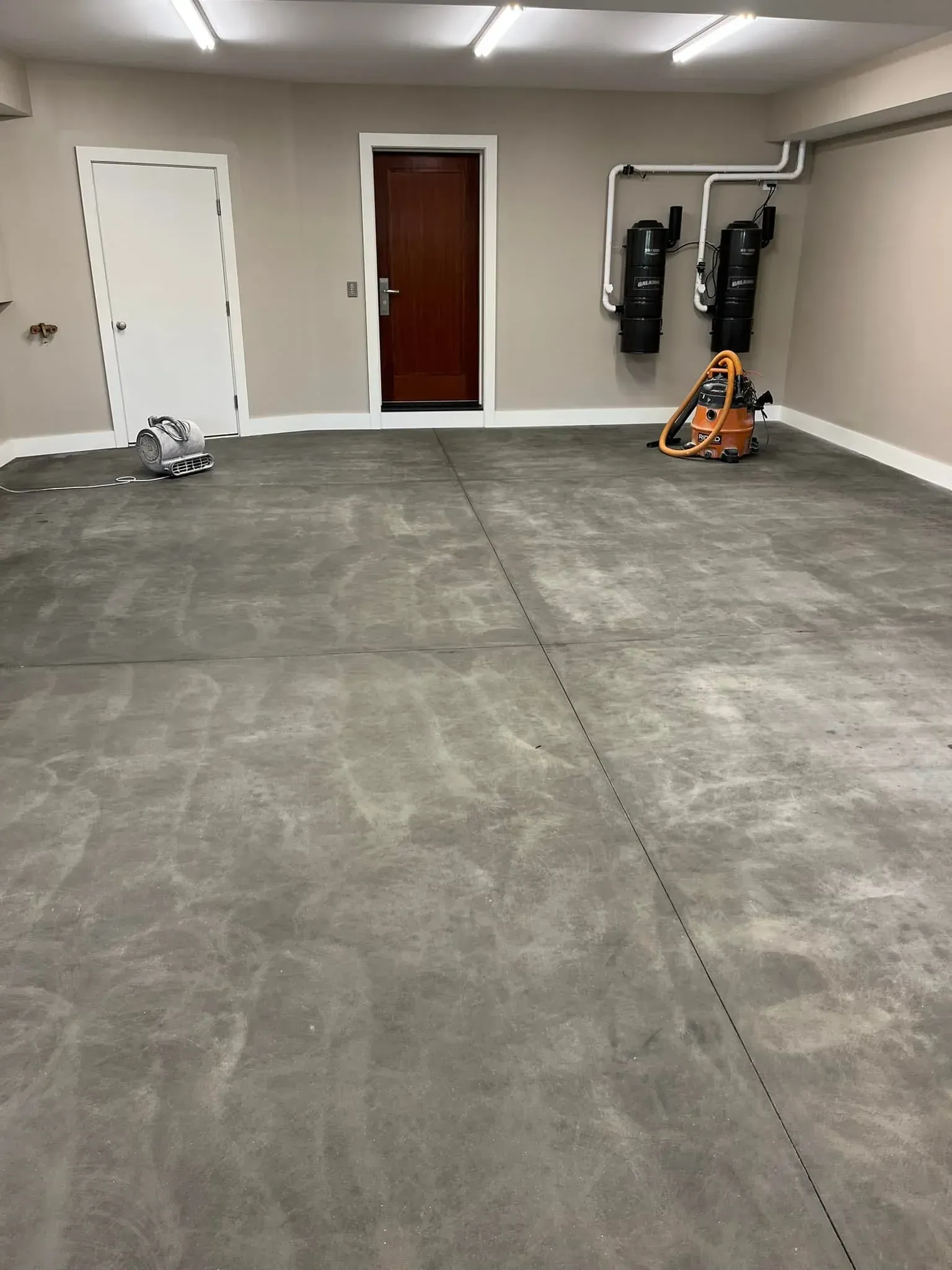 A garage with a concrete floor and a door.