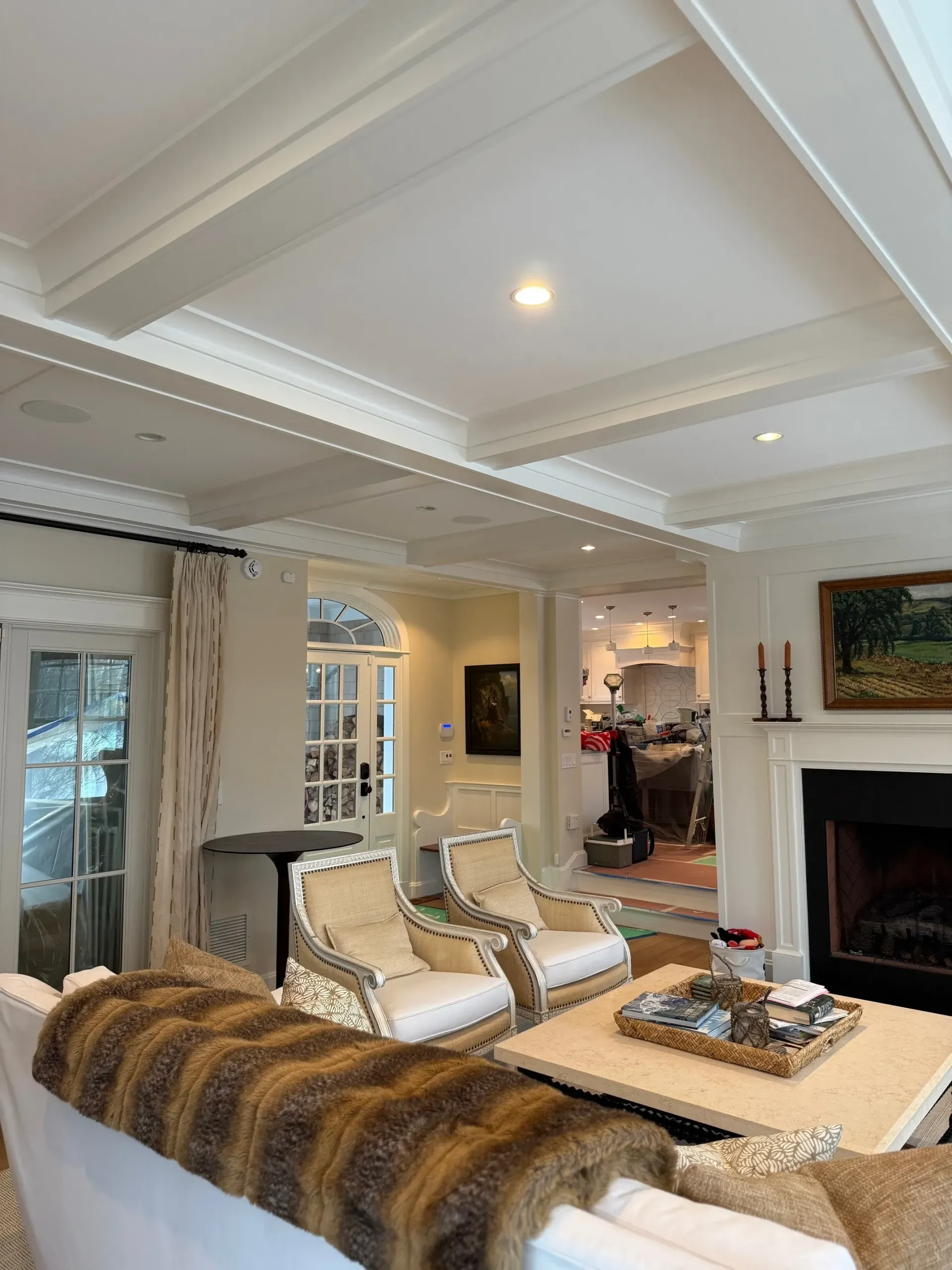A living room with a couch , chairs , coffee table and fireplace.