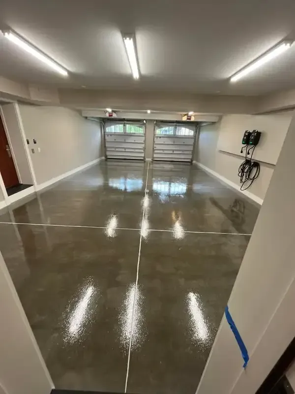 A garage with a shiny concrete floor and a garage door.