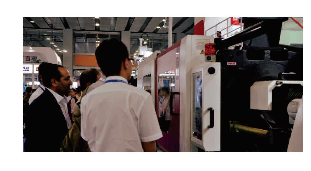 People interested in the Hwamda machine at a trade show.