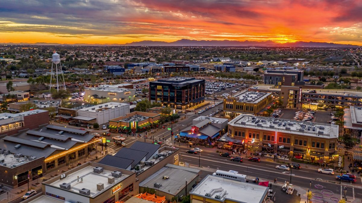 An aerial view of a city at sunset with a sunset in the background.
