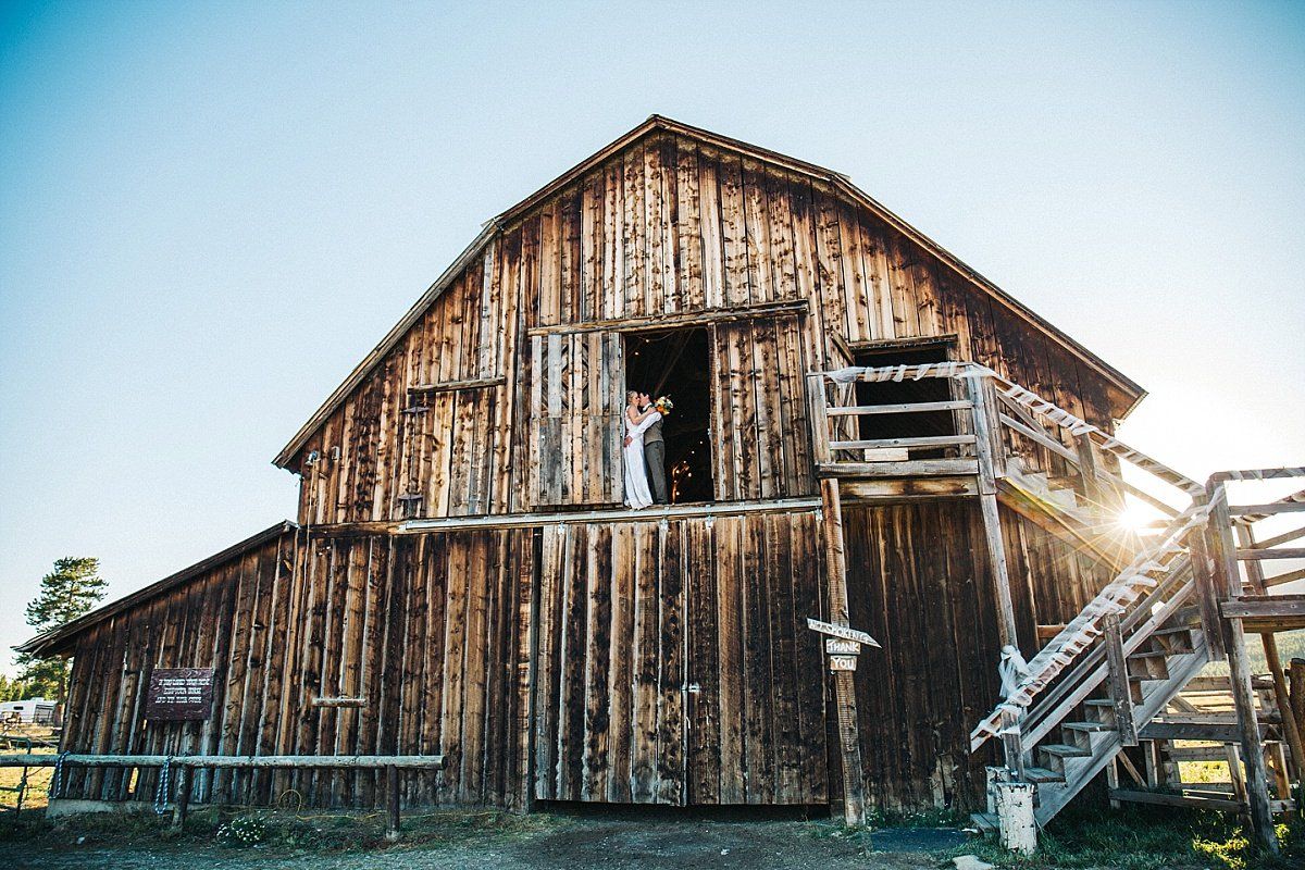 newly weds kissing on a barn