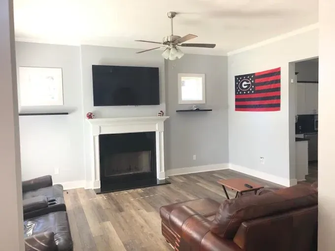 A living room with a fireplace and a flat screen tv
