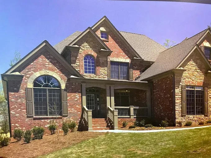 A large brick and stone house with a large porch