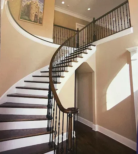 A curved staircase with a picture of a castle above it
