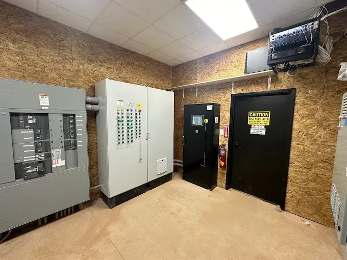 A room with a lot of electrical equipment and a door.
