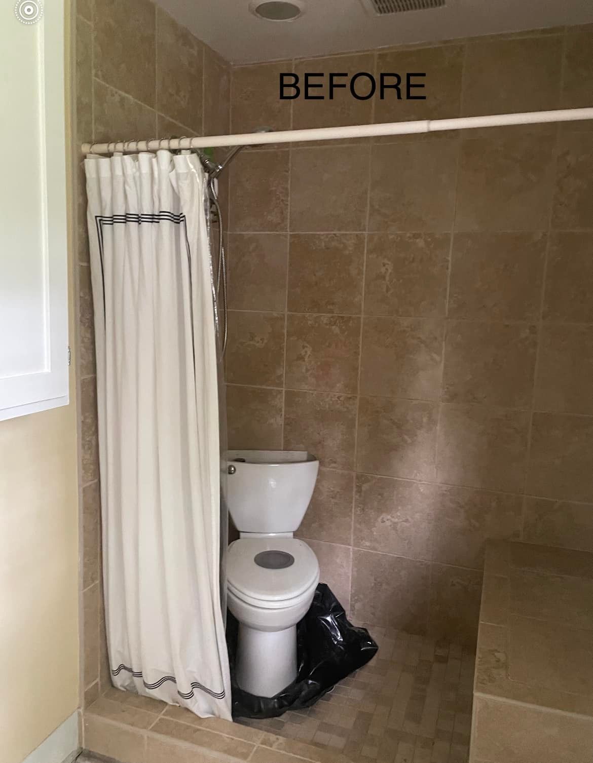 A bathroom with a toilet and a shower curtain.