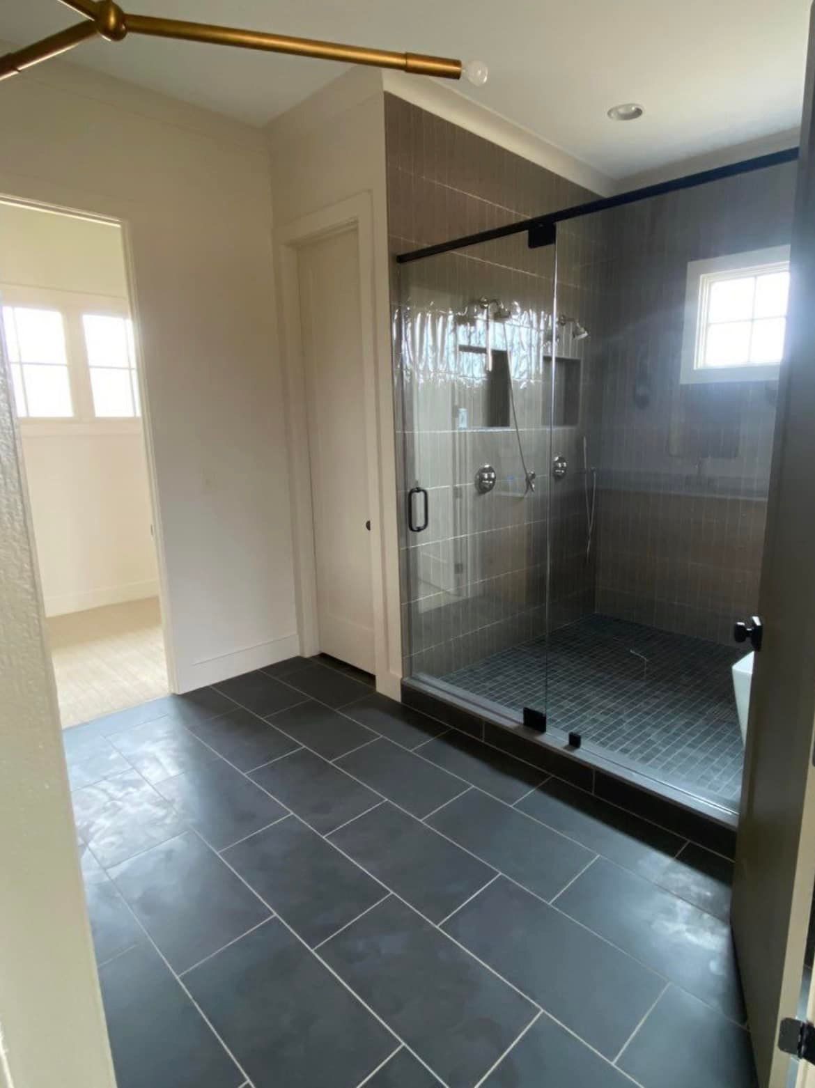 A bathroom with a walk in shower and a tiled floor.