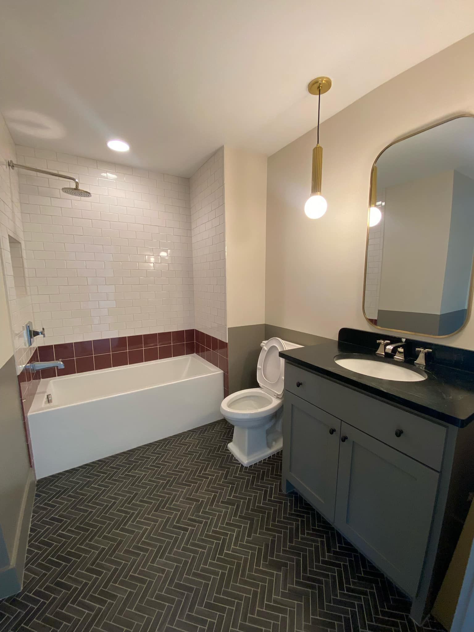 A bathroom with a toilet , sink , bathtub and mirror.