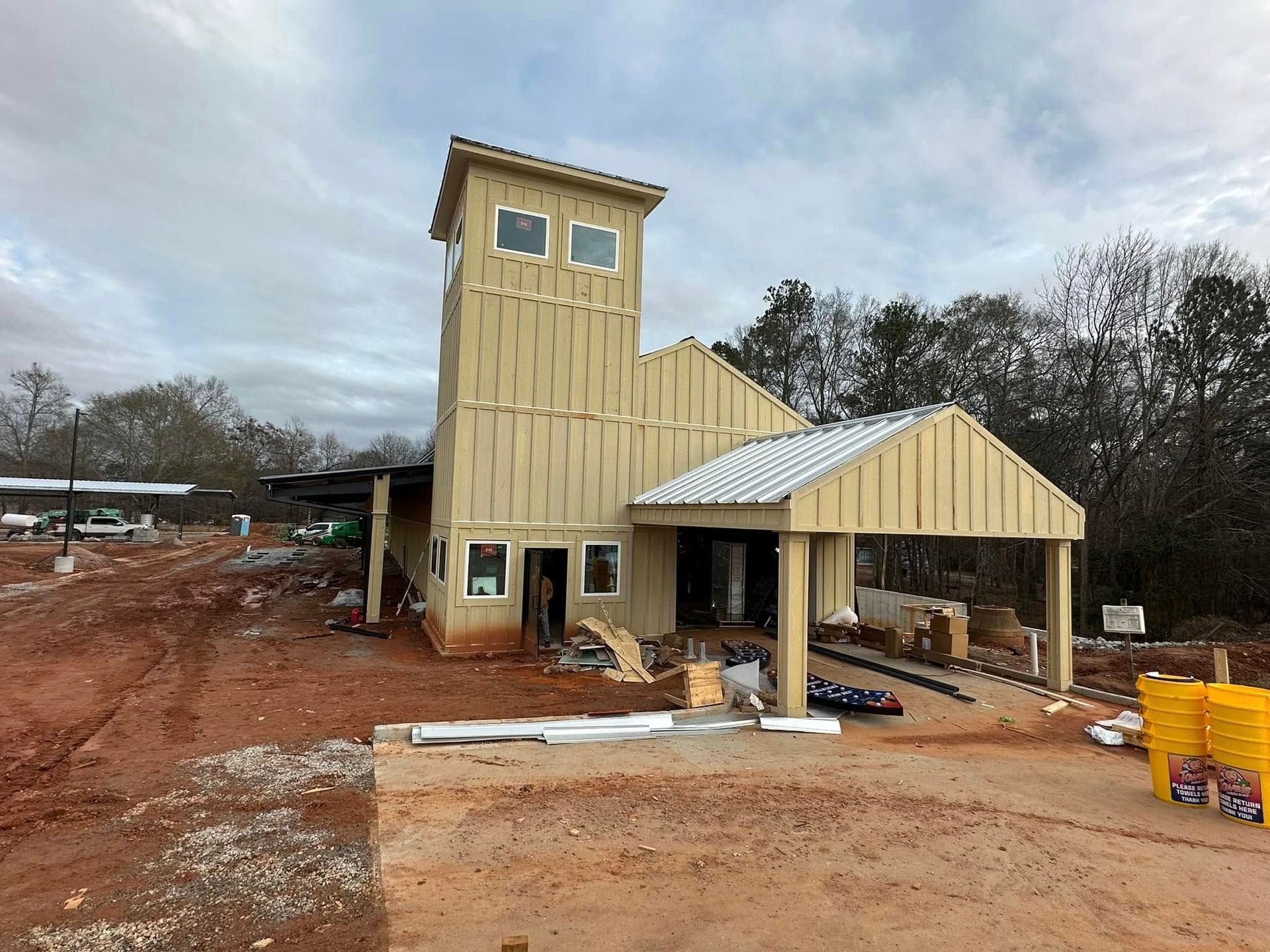 A large building is being built in the middle of a dirt field.