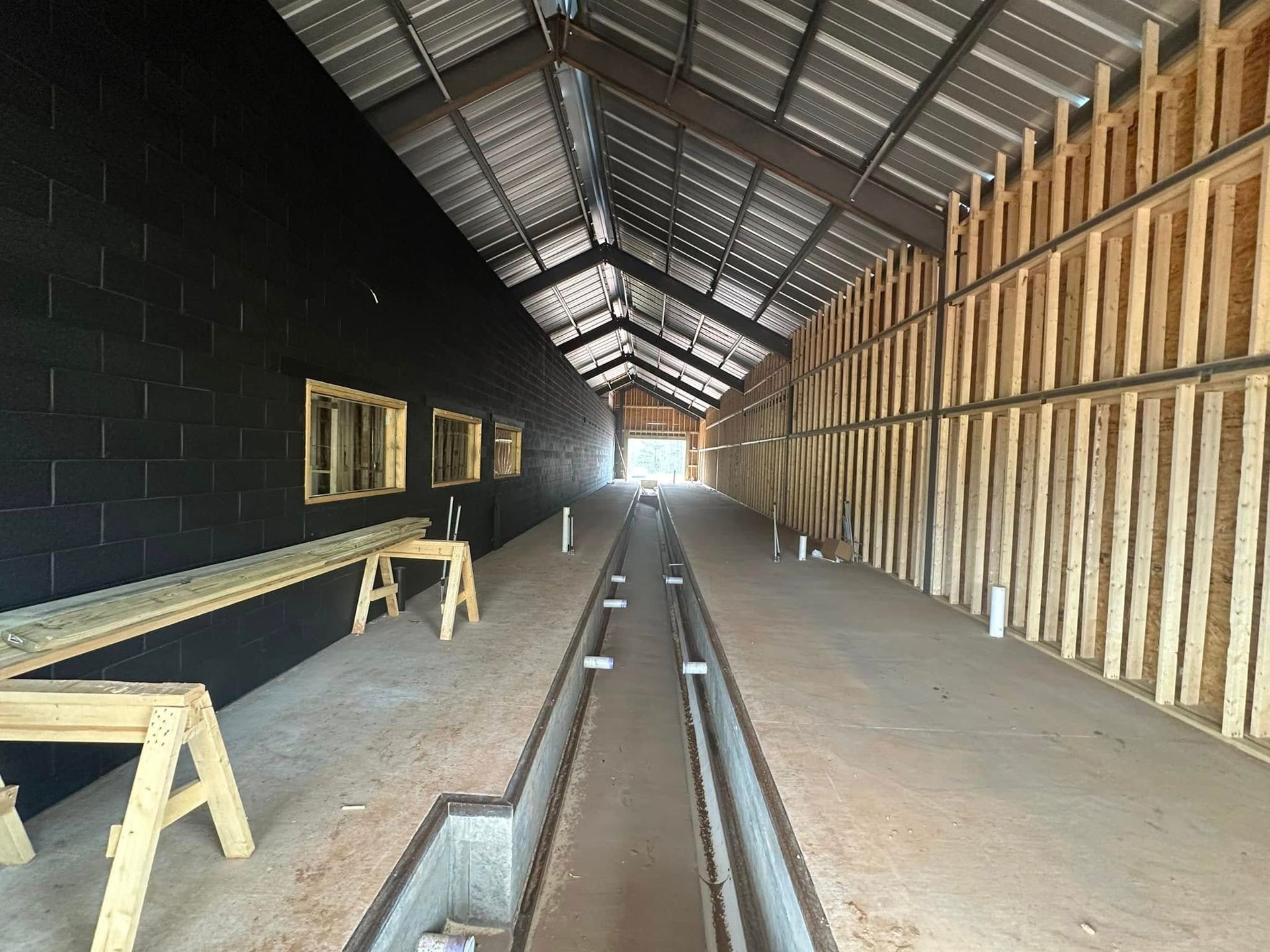 The inside of a building under construction with a drain in the middle.