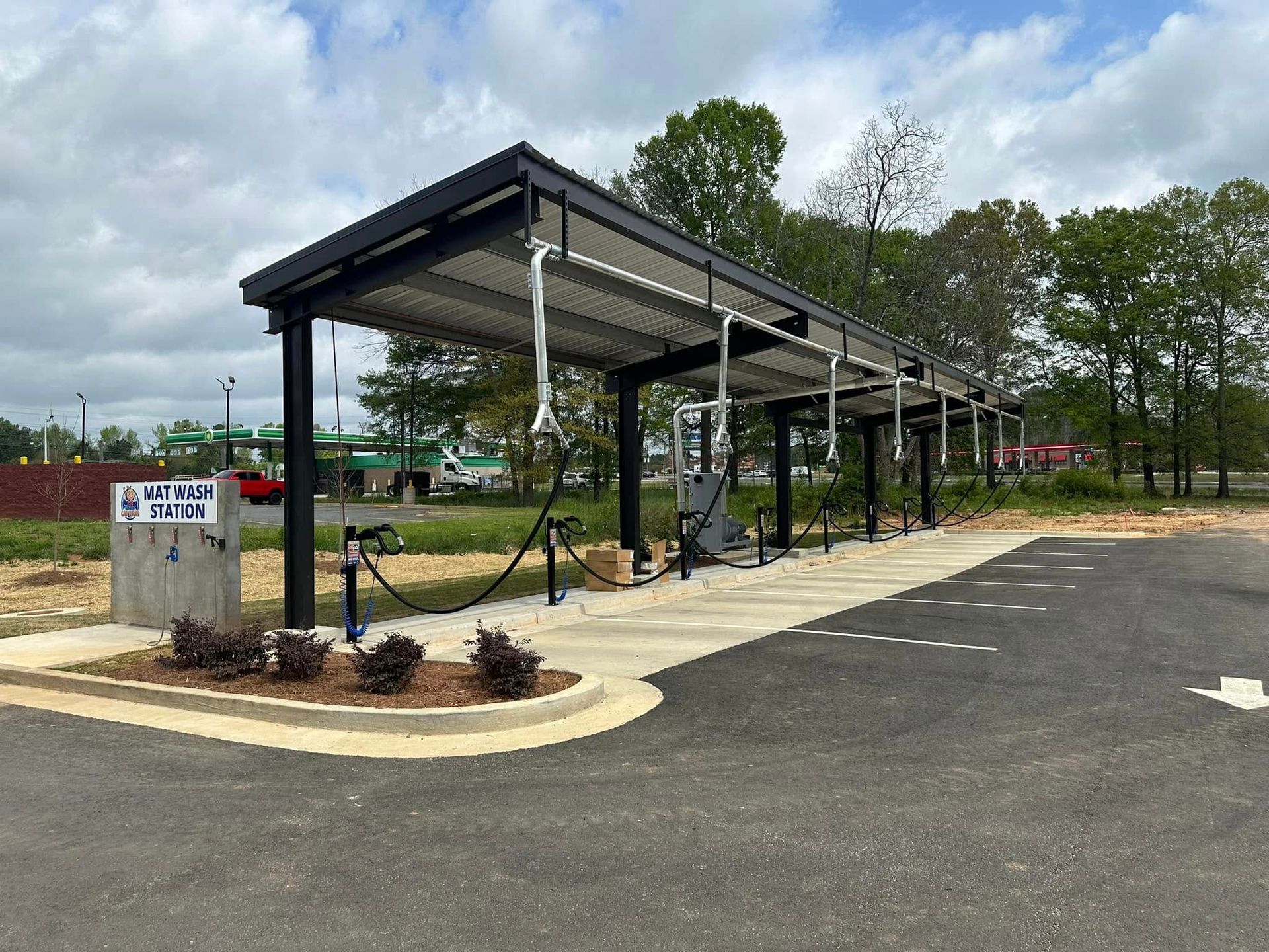A car wash in a parking lot with a canopy over it.