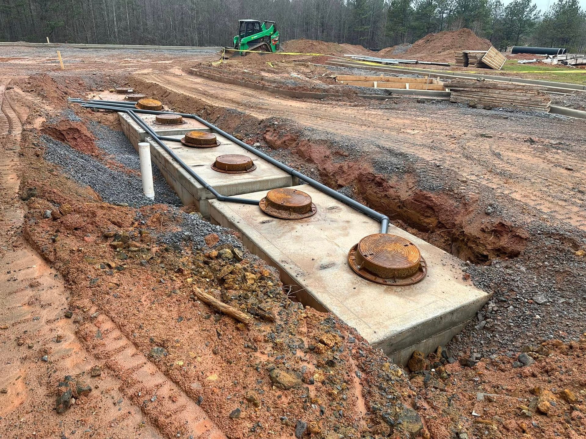 A large concrete structure is sitting in the middle of a dirt field.