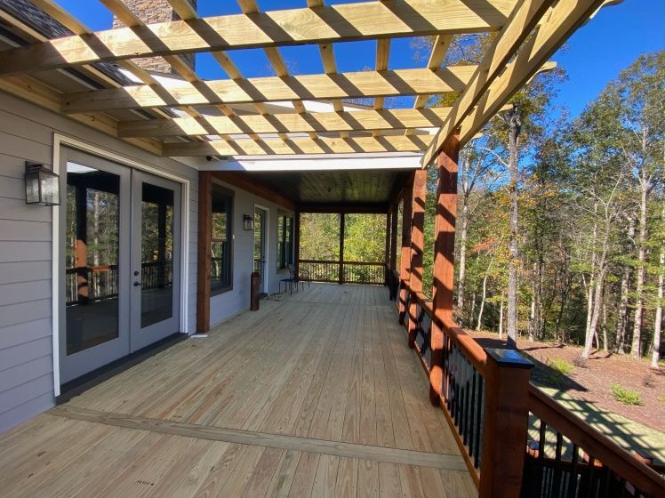 A large wooden deck with a pergola over it