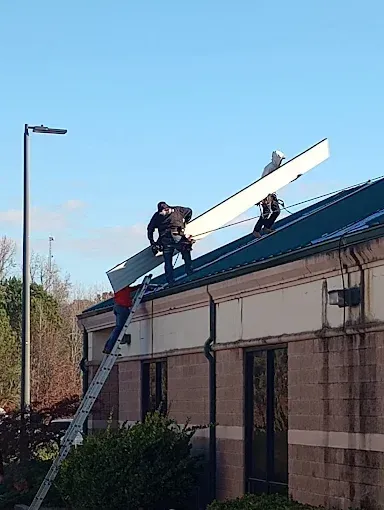Two men are working on the roof of a building.