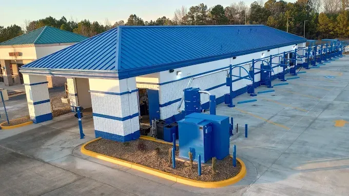An aerial view of a car wash with a blue roof.