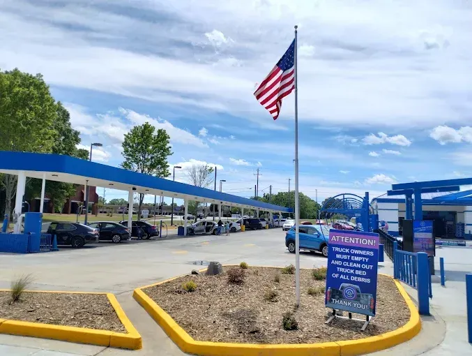 An american flag is flying in front of a car wash.