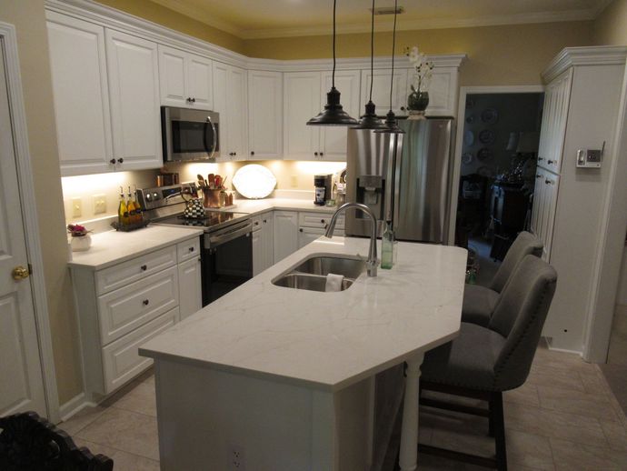 A kitchen with white cabinets and stainless steel appliances