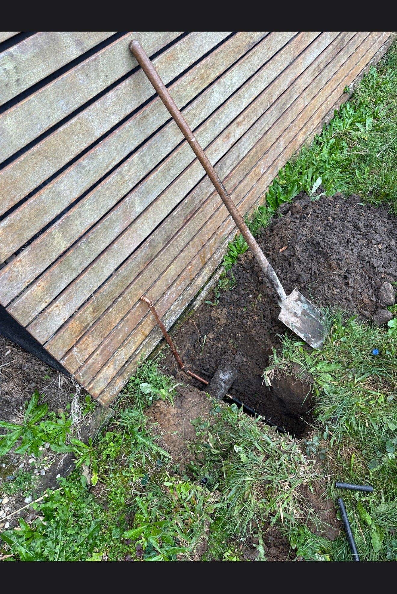 A Man is Fixing a Pipe With a Wrench in a Bathroom — R.K. Plumbing & Gas In Bli Bli, QLD