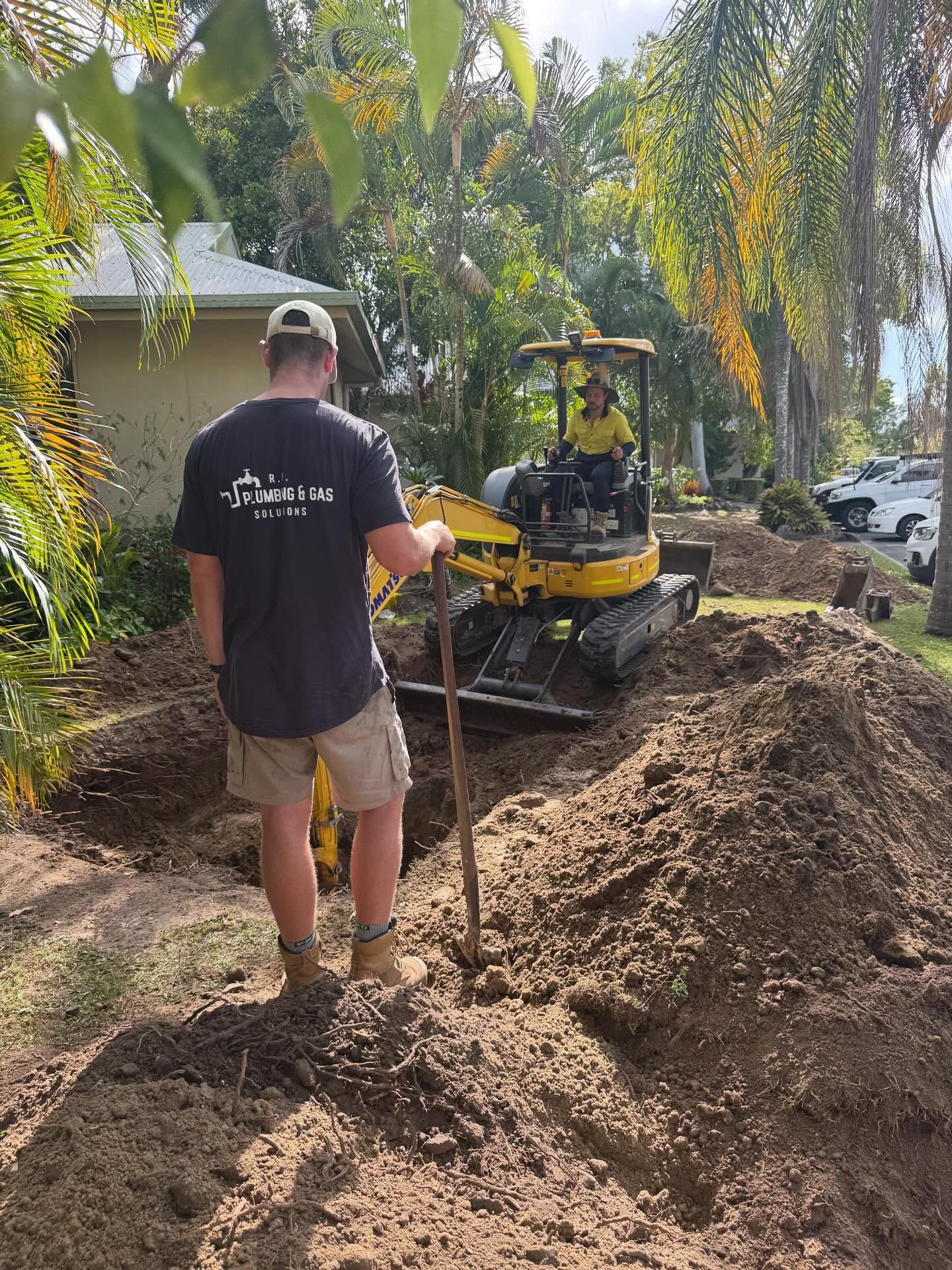 A Man is Kneeling Down in a Kitchen Looking Under a Sink — R.K. Plumbing & Gas In Bli Bli, QLD