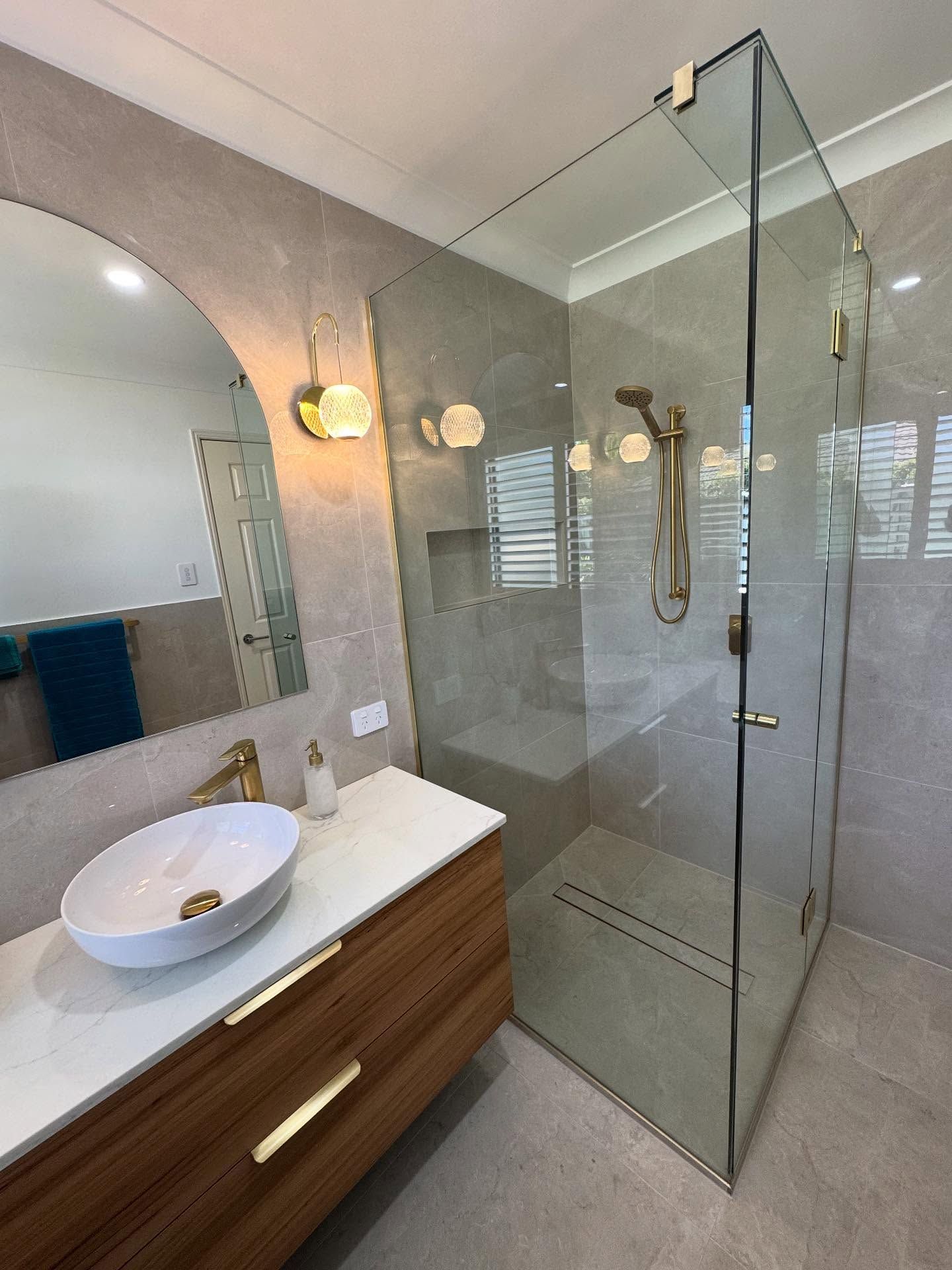 A Man is Kneeling on the Floor Working on Pipes — R.K. Plumbing & Gas In Bli Bli, QLD