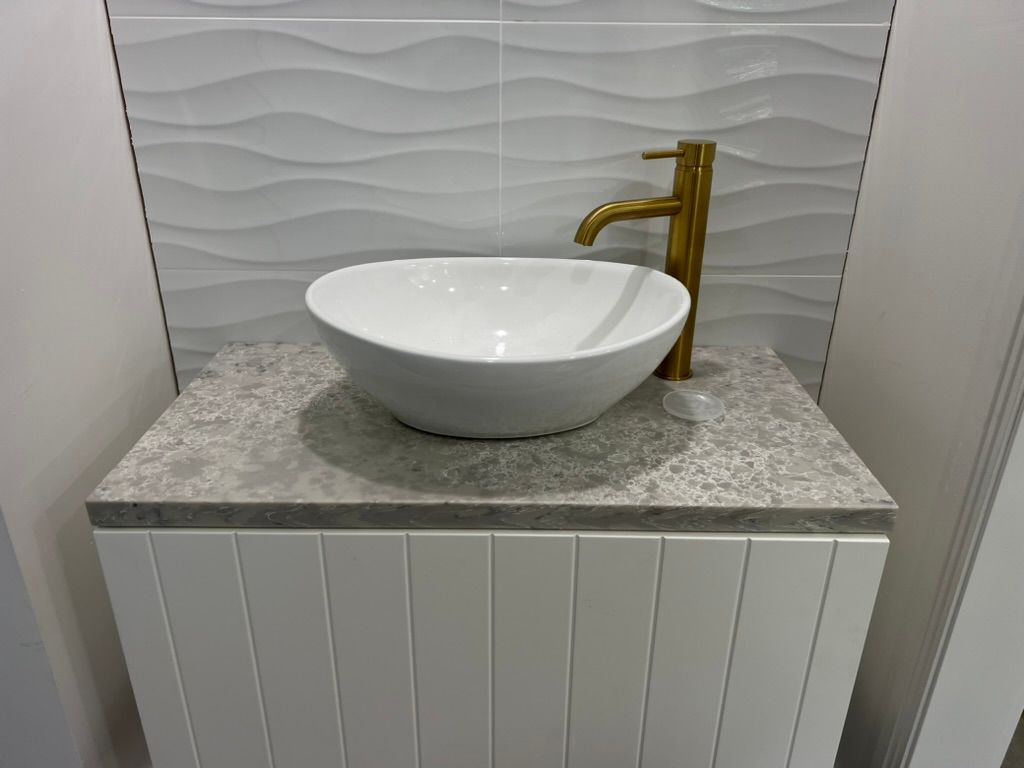 A White Sink is Sitting on Top of a White Counter in a Bathroom — R.K. Plumbing & Gas In Bli Bli, QLD