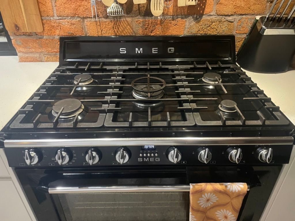 A Black Smeg Stove Top Oven is Sitting on a Kitchen Counter — R.K. Plumbing & Gas In Bli Bli, QLD