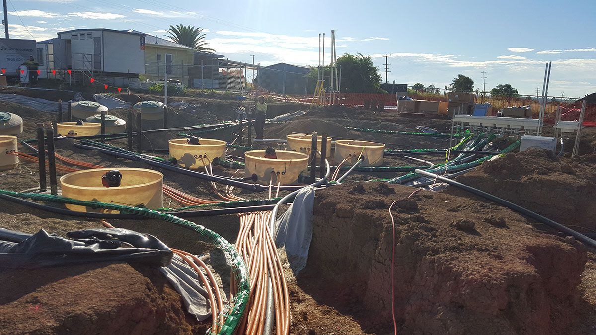 A construction site with a lot of electrical wires coming out of the ground.