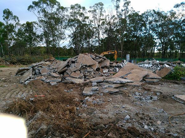 A pile of rubble in a field with trees in the background