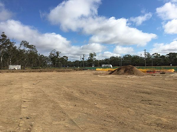 A large dirt field with trees in the background and a pile of dirt in the middle.