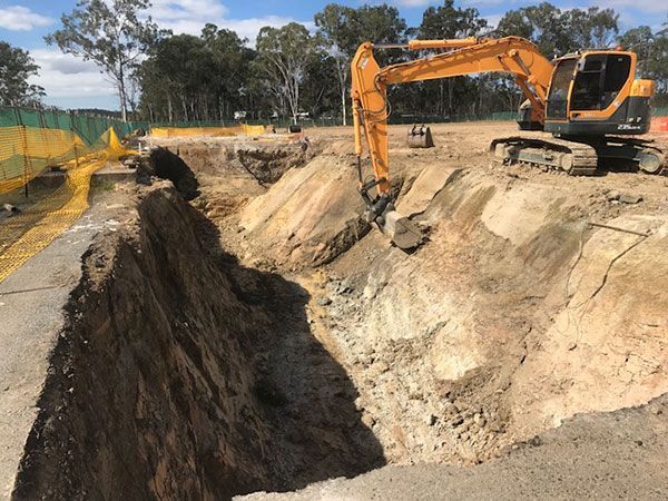 A large excavator is digging a hole in the ground.