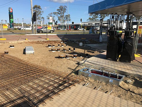 A construction site with a gas station in the background.