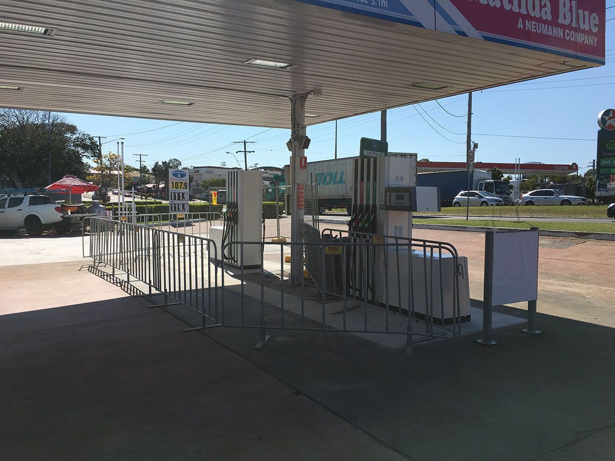 An empty gas station with a fence around it.
