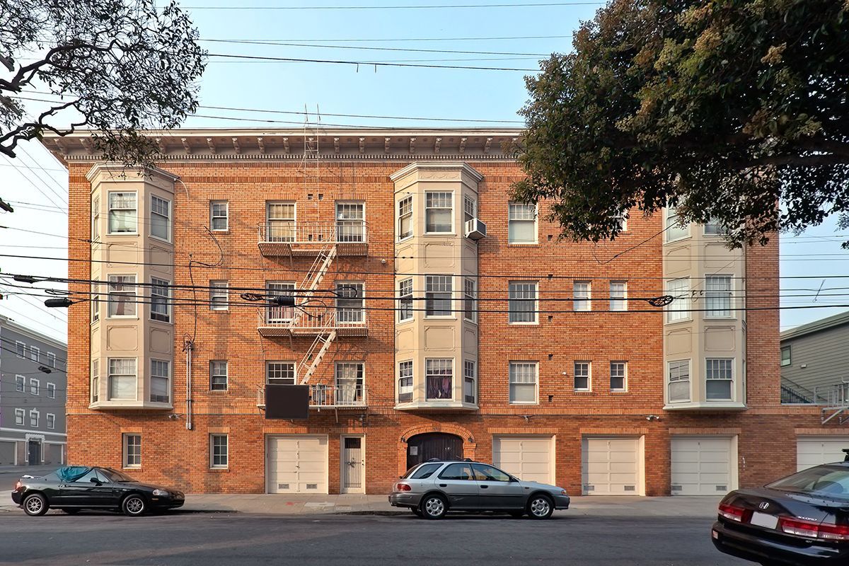 390 Bartlett- two cars are parked in front of a large brick building