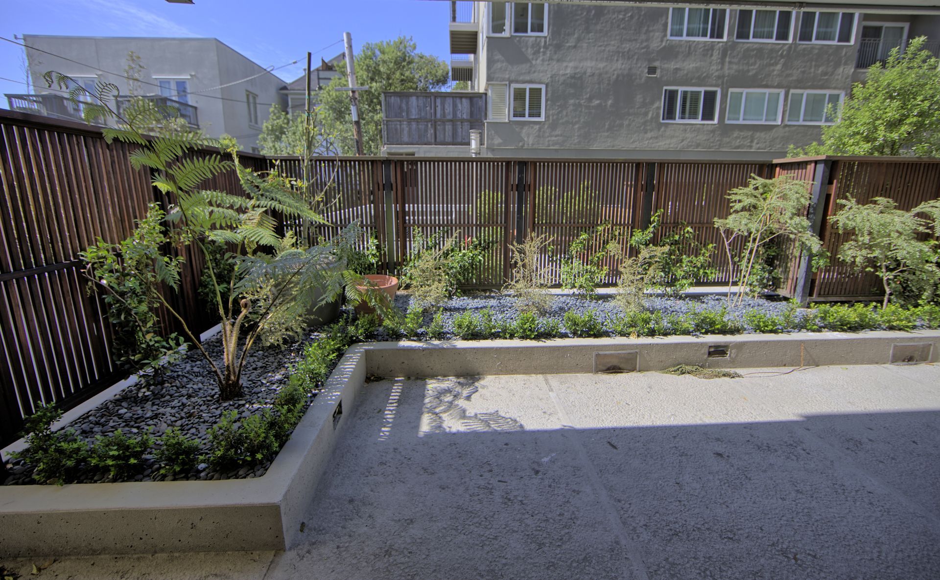390 Bartlett - a garden with a fence and trees in front of a building