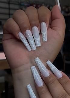 A close up of a woman 's hand with long white nails.