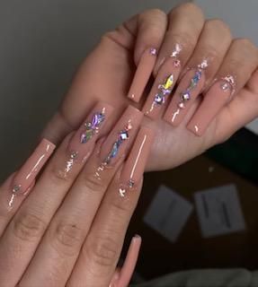 A close up of a person 's nails with rhinestones on them.