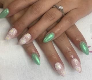 A close up of a woman 's nails with a ring on her finger.