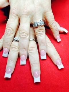 A close up of a woman 's nails with rings on them