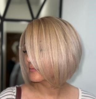 A woman with blonde hair is wearing a striped shirt.