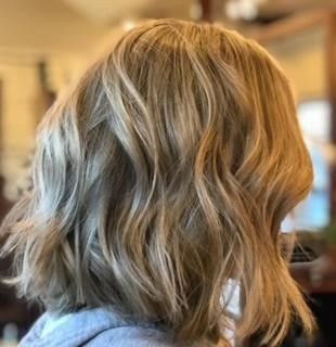 A woman with blonde hair is wearing a gray hoodie.