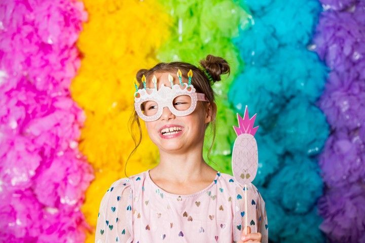 Girl at a colorful birthday photo booth.