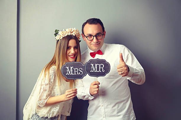 Bride and groom holding wedding props