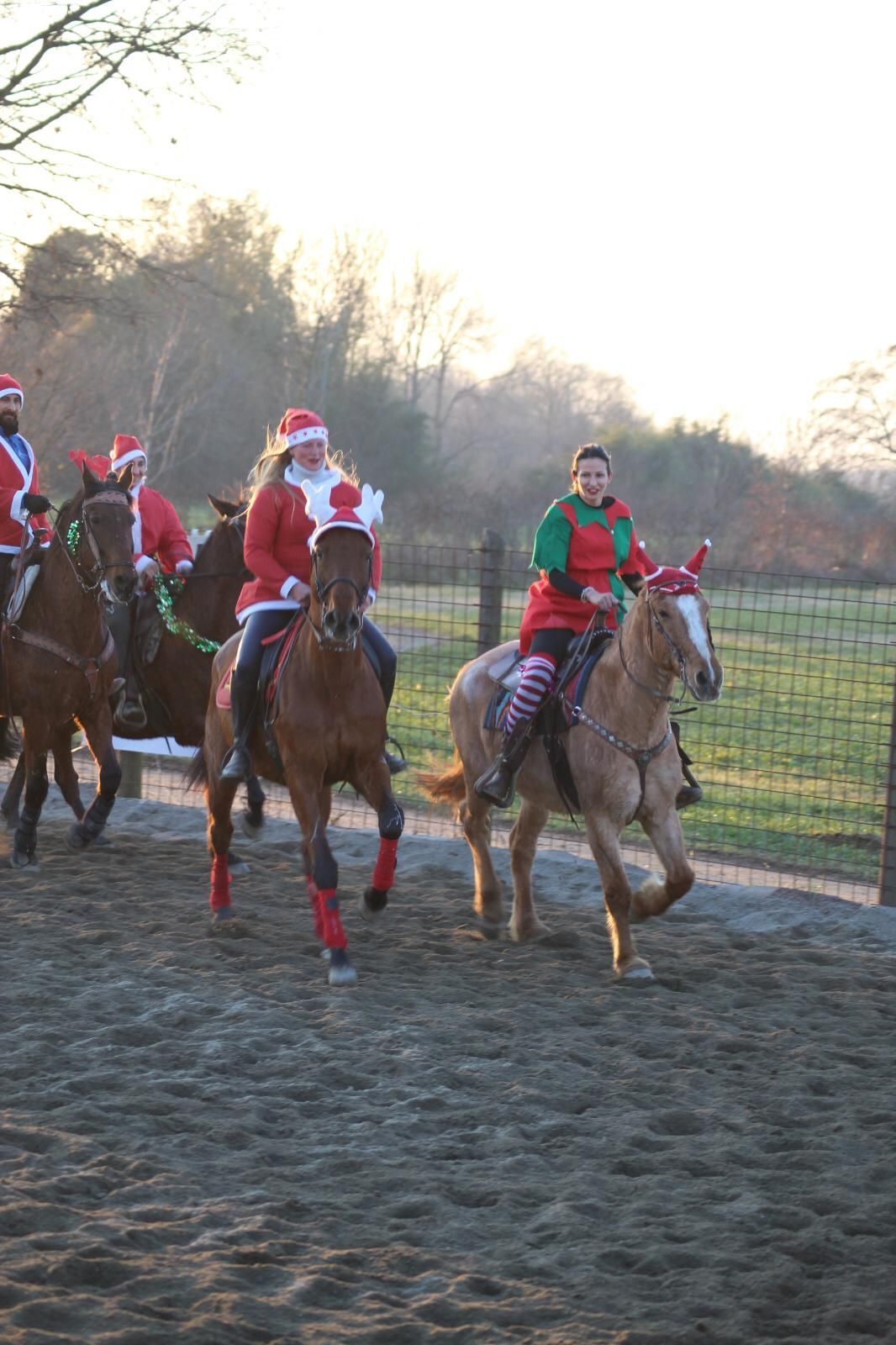 gruppo di persone vestite da Babbo Natale cavalcano dei cavalli